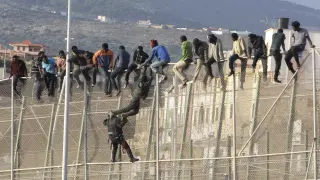 Un centenar de inmigrantes permanecen encaramados en la valla fronteriza entre Melilla y Marruecos en una imagen de archivo.