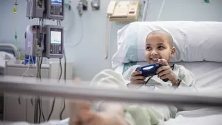 Uno de los niños tratados en el hospital Miguel Servet juega con una de las nuevas consolas.