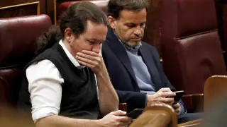 Pablo Iglesias y Jaume Asens, de Podemos, consultan el móvil en el Congreso.