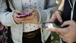 Dos adolescentes usando el móvil.