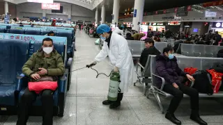 Un operario desinfecta este jueves una zona de espera para pasajeros en una estación de tren en China.