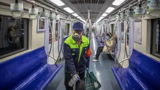 Un trabajador del metro de Pekín desinfecta un vagón de metro.