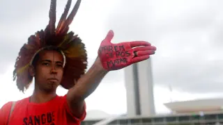 Un hombre indígena muestra su mano con el lema "dejen de matarnos", durante una protesta contra el gobierno de Bolsonaro