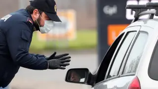 Un policía de Codogno con mascarilla advierte a un conductor que circula por la carretera entre este municipio y Casalpusterlengo.