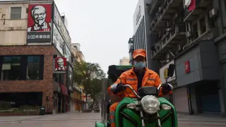 Un trabajador sanitario en su moto este martes por una calle de Wuhan, zona 0 del coronavirus.