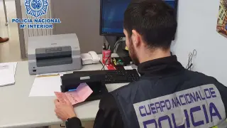Un agente de la Policía Nacional comprueba la autenticidad del carnet de conducir del detenido.