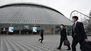 Ciudadanos pasan por delante del estadio olímpico de baloncesto en Tokio