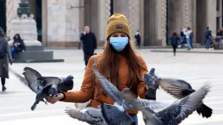 Una turista con mascarilla en Milán.