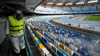 FILE PHOTO: A cleaner wearing a protective suit sanitises seats at the San Paolo stadium ahead of the second leg of the Coppa Italia semi-final between Napoli and Inter Milan, which has since been postponed as part of measures to contain the coronavirus outbreak, in Naples, Italy, March 4, 2020. REUTERS/Ciro De Luca/File Photo [[[REUTERS VOCENTO]]] HEALTH-CORONAVIRUS/ITALY-SPORTS