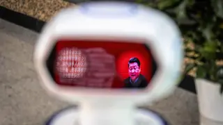 Una imagen del presidente de China Xi Jinping, reflejada en el visor de un robot que detecta la temperatura corporal.