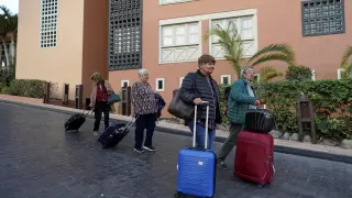 Varios turistas abandonan el hotel H10 Costa Adeje Palace de Tenerife en el que estaban confinados por el coronavirus.