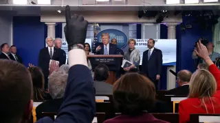 A reporter wears a latex glove while trying to ask a question of U.S. President Donald Trump during a news briefing on the coronavirus (COVID-19) at the White House in Washington
