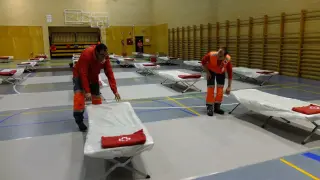 El Equipo de Respuesta Inmediata de Emergencia de Cruz Roja en Huesca ha estado montando este martes las camas y una carpa en el pabellón de la Universidad.