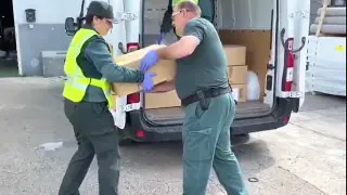 Agentes de la Guardia Civil cargan el material donado.