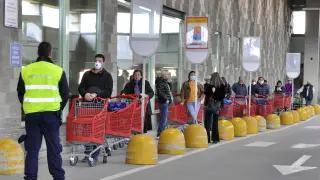 Gente haciendo fila a la entrada de un supermercado de la ciudad italiana de Aosta este viernes.
