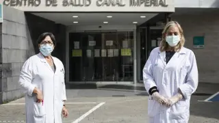 La enfermera Pilar Arilla (a la ziquierda) y la médico Pilar López Esteban, en la entrada del centro de salud Canal Imperial, en el barrio de Venecia, el pasado viernes.