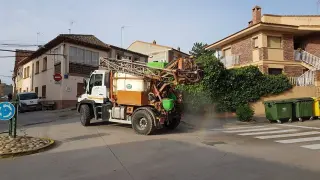Un agricultor utiliza su maquinaria para desinfectar las calles en un municipio aragonés.
