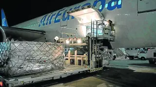 Operarios bajan del avión la carga con 1,2 millones de mascarillas que llegó ayer al aeropuerto de Barajas.