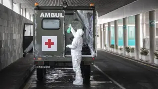 Un militar desinfecta su ambulancia tras dejar en el hospital Miguel Servet a un enfermo, este martes.