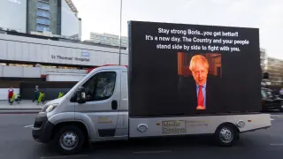 Una furgoneta transporta una pantalla con la imagen de Boris Johnson junto al hospital donde se encuentra ingresado.