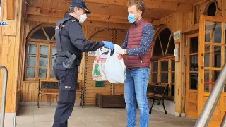Un agente de la Policía Nacional entrega material al director de la residencia La Abubilla, en Yéqueda