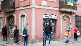 Vecinos en una fila para entrar en una tienda en el barrio de la Barceloneta.