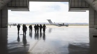 Los pilotos de aviones del Ala 31, protegidos con mascarillas y guantes, salen del hangar hacia la plataforma de la Base Aérea de Zaragoza.