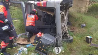 Los bomberos, durante el rescate del conductor herido en Ariño.