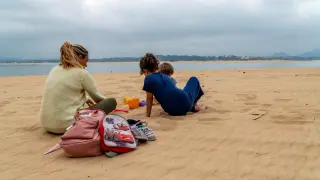 Una mujer con sus dos hijos en la Playa de los Peligros de Santander