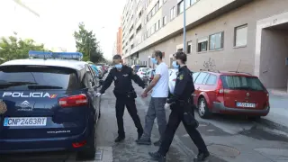 Agentes de la Policía Nacional introducen al guardia civil detenido en el coche patrulla tras registrar su domicilio.