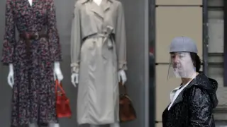 Una mujer protegida con una mascara ante un escaparate este jueves en Bilbao, dentro del estado de alarma por la pandemia de coronavirus.