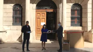 La alcaldesa, Emma Buj, y el primer teniente de alcalde, Ramón Fuertes, entregan el material al presidente de la CEOE, Ángel Muela.