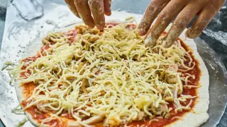 Una pizza casera puede propiciar buenos ratos en familia aprendiendo a cocinar.