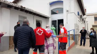 Voluntarios de Cruz Roja acompañan a la residencia de Sariñena a un usuario al que han trasladado desde Huesca.