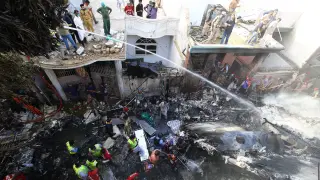 Decenas de trabajadores de servicios de emergencias y voluntarios buscan a las víctimas del accidente aéreo en Karachi (Pakistán)