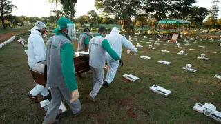 Trabajadores del cementerio Campo de Esperanza entierran una víctima de la pandemia este jueves, en Brasilia (Brasil).