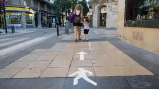 La señalización en las aceras ayuda a los ciudadanos a mantener los dos metros de distanciamiento entre las personas por la calle.