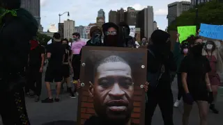 Un manifestante en Detroit con un cartel con el rostro de Georges Floyd, muerto a manos de la Policía,