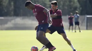 Carlos Kevin intenta avanzar con el balón ante la presión de Juan Carlos, en un entrenamiento de la SD Huesca.