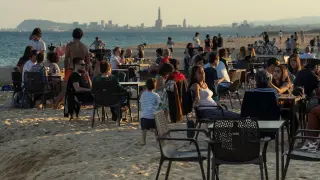 Varias personas tomando algo en la playa de Barcelona