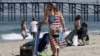 Una mujer con un vestido estampado con la bandera de EE. UU., este viernes en una playa de San Diego, California.