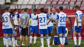 Los jugadores del Real Zaragoza escuchan las consignas de Víctor Fernández en una de las pausas de hidratación este viernes en Gerona.