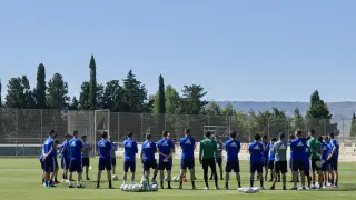 Los futbolistas del Real Zaragoza, en grupo, atiende el discurso de Víctor Fernández.
