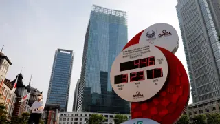 FILE PHOTO: A man wearing a protective mask walks past a countdown clock for the Tokyo 2020 Olympic Games amid the coronavirus disease (COVID-19) outbreak in Tokyo