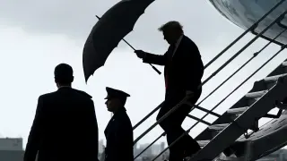 Trump se resguarda de la lluvia al bajar del Air Force One en Fort Lauderdale, Florida, este viernes.