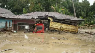 A truck is submerged in mud after flash floods swept through Radda Village, as several people were killed and dozens remain missing in North Luwu in Sulawesi