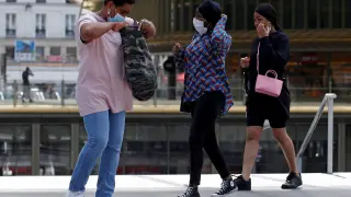 Tres personas con mascarilla, en una zona comercial del centro de París, este jueves.