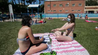 Dos usuarias del C. D. M. Salduba de Zaragoza disfrutaron ayer del sol con mascarilla.