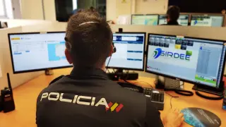 Un agente de la Policía Nacional ante varios ordenadores.