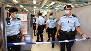 Hong Kong police officers set up police cordon as they search Apple Daily office in Hong Kong